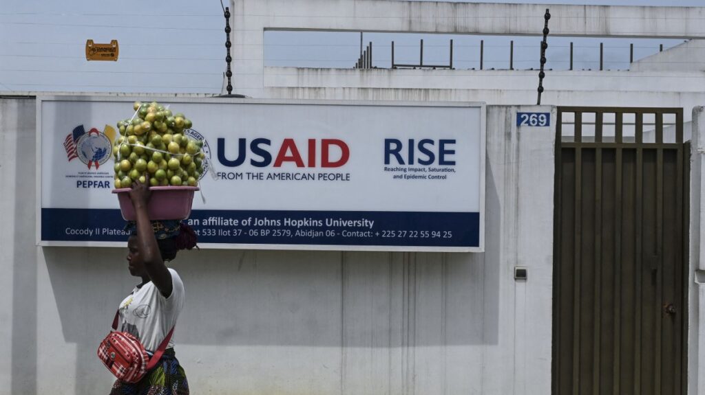 A Street vendor walks past the United States Agency for International Development (USAID) office, Abidjan, Cote d'Ivoire, March 22, 2025. (AFP Photo)