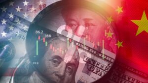 A magnifier glass focuses on a U.S. dollar and yuan banknote with U.S. and China flags in the background. (Shutterstock Photo)