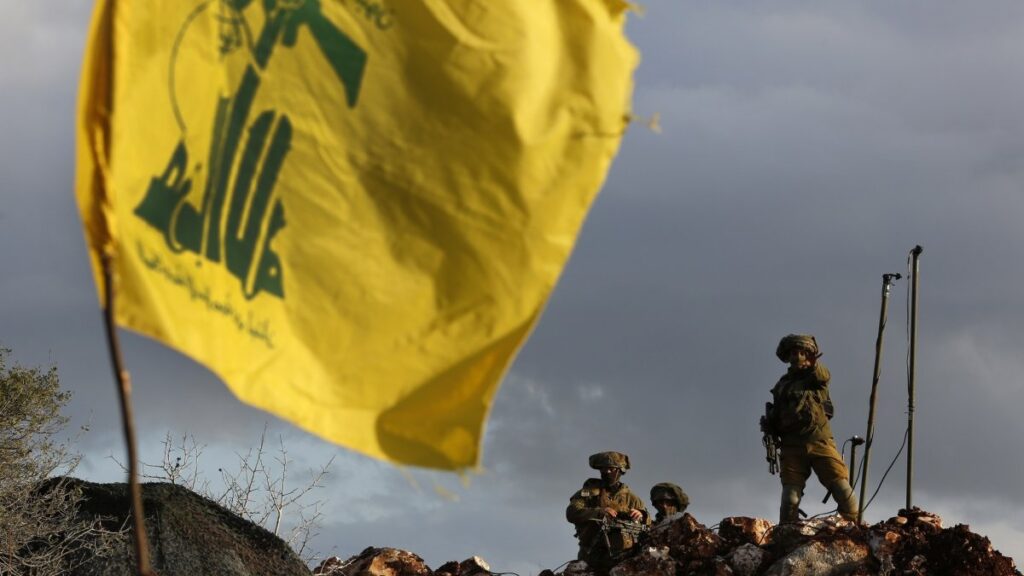 Israeli soldiers stand next to cameras at their new position in front of a Hezbollah flag, near the Lebanese southern border village of Mays al-Jabal, Lebanon, Dec. 13, 2018. (AP Photo)