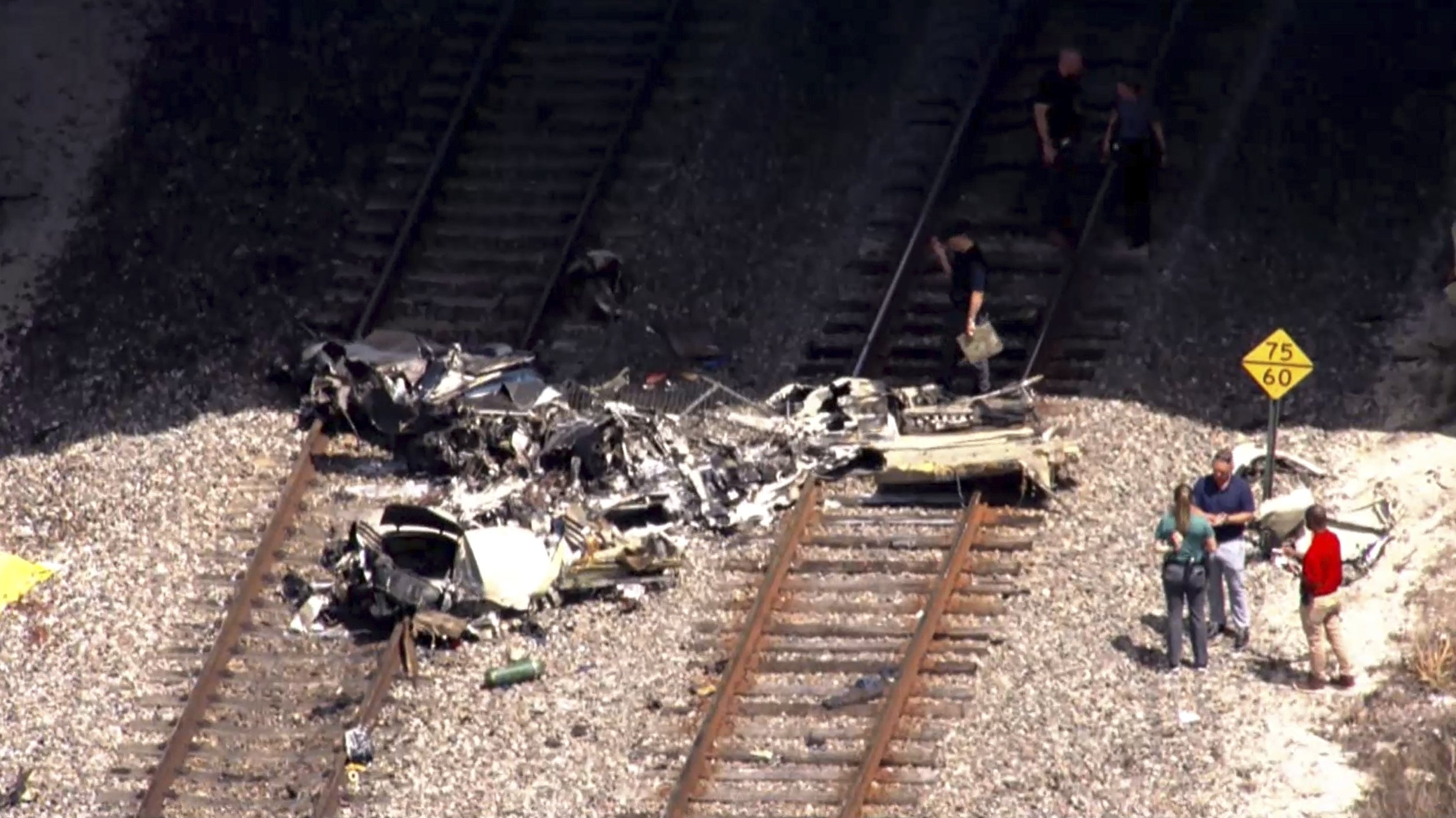 377234 In this image taken from video provided by WSVN-TV, emergency personnel respond to the area where a small plane crashed on the railroad tracks beneath the overpass near Interstate 95 in Boca Raton, Fla., Friday, April 11, 2025. (WSVN-TV via AP)