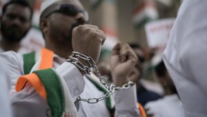A Congress Party member wears shackles during a protest to condemn the reported mistreatment of Indian immigrants during their deportation from the United States, Hyderabad, India, Feb. 7, 2025. (AP Photo)
