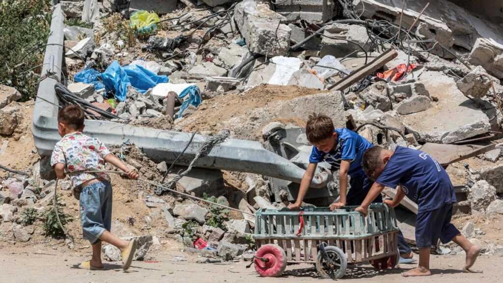 A boy pulls as other boys push a cart past the rubble of a destroyed building in Gaza City, Gaza, Palestine, April 21, 2025. (AFP Photo)