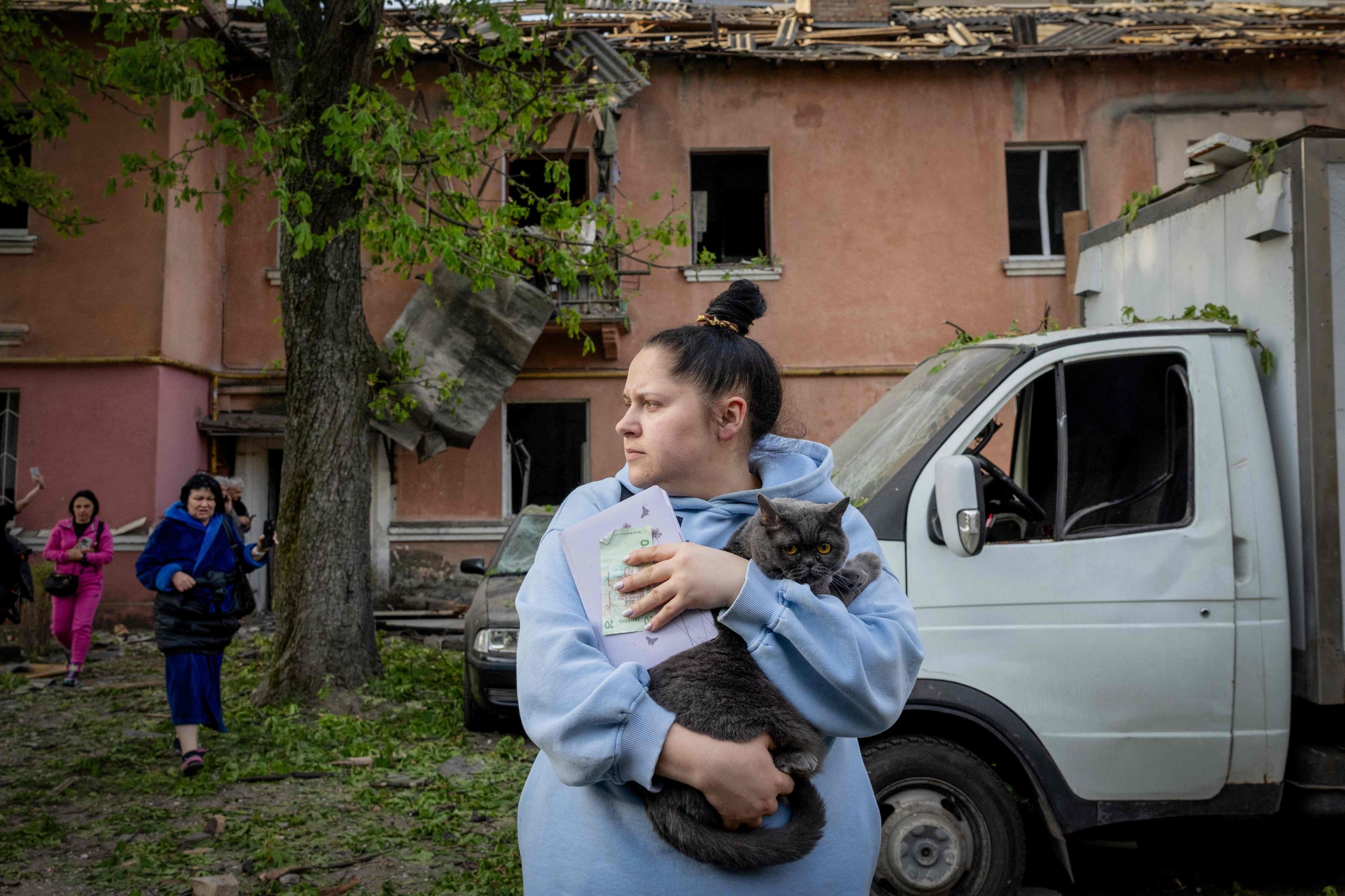 379178 A local holds a cat in front of damaged apartment buildings following a Russian missile attack in Kyiv, Ukraine, April 24, 2025. (AFP Photo)