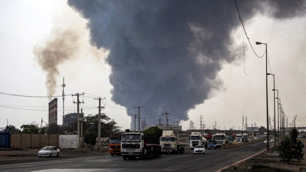 A thick plume of smoke billows as motorists drive their vehicles along a highway near the source of an explosion at the Shahid Rajaee port dock southwest of Bandar Abbas in the Hormozgan province, Iran, April 26, 2025. (AFP Photo)