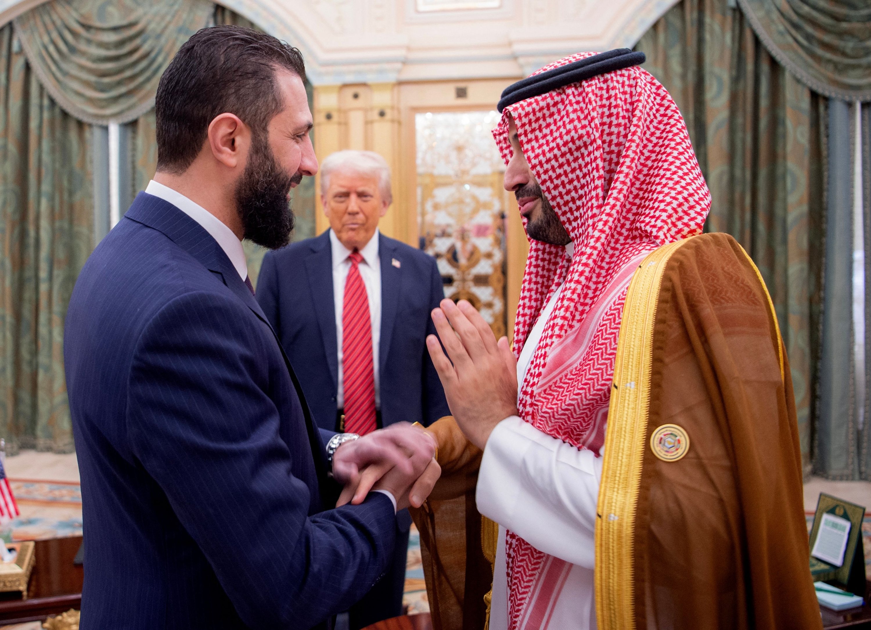 382256 Saudi Crown Prince Mohammed bin Salman (R) greets Syria's interim president Ahmed al-Sharaa as U.S. President Donald Trump looks on, in Riyadh, Saudi Arabia, May 14, 2025. (AFP Photo)