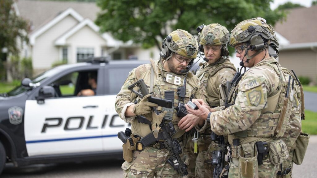 Armed FBI agents have a meeting to strategize as they search for an active shooter in Brooklyn Park, Minnesota, U.S., June 14, 2025. (AP Photo)