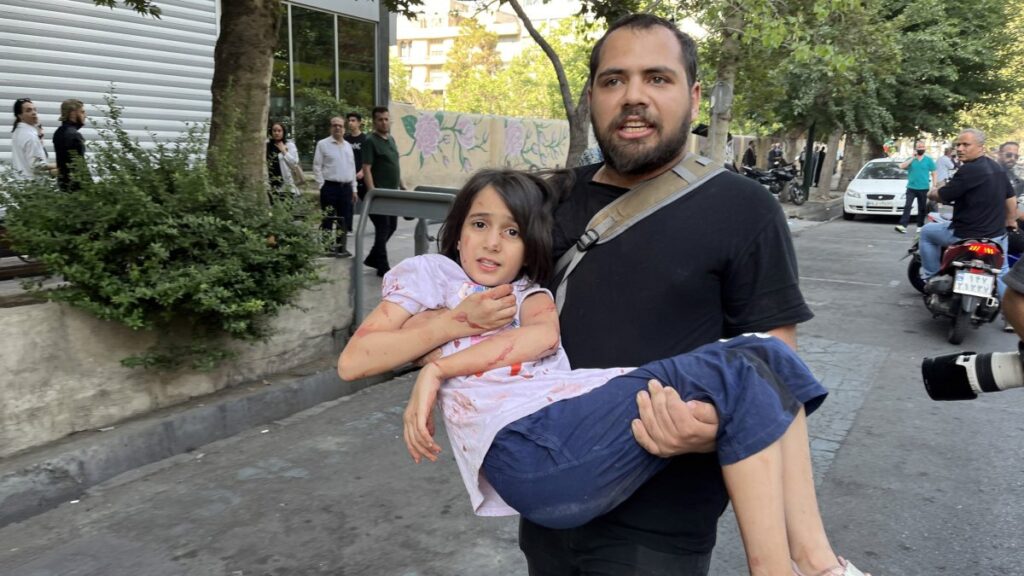 A man carries his wounded child following an Israeli airstrike in central Tehran, Iran, June 15, 2025. (EPA Photo)