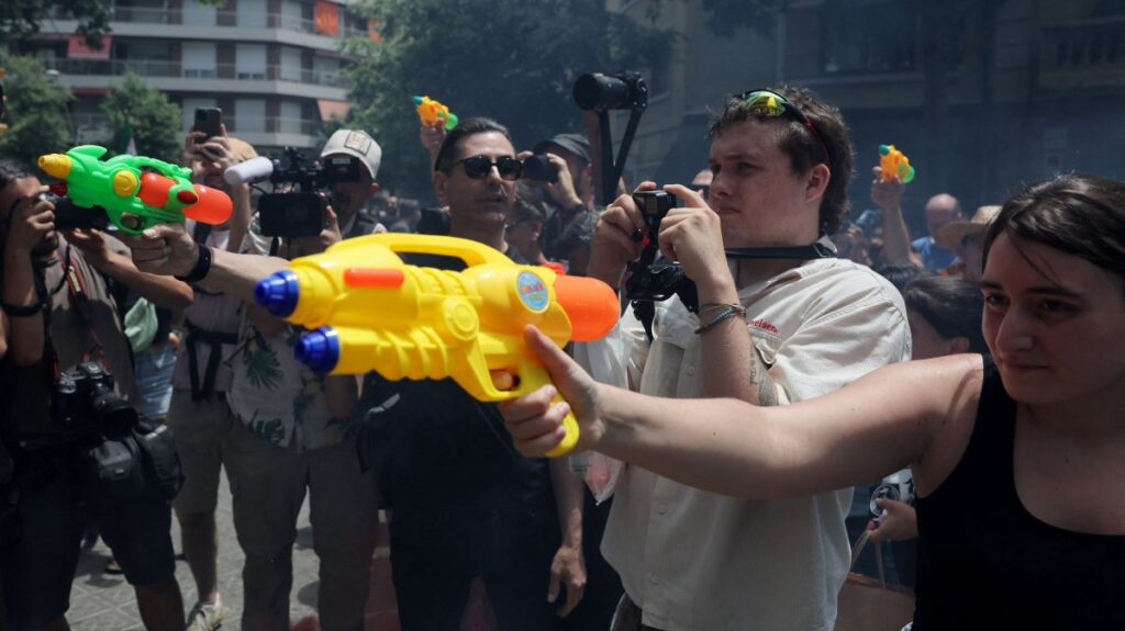Protesters spray water at a hotel using toy water guns during a demonstration against mass tourism in Barcelona, Spain, June 15, 2025. (AFP Photo)