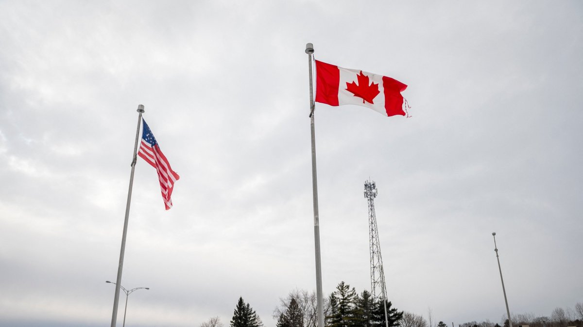 The Canadian and U.S. flags fly near the Canada-U.S. border in Blackpool, Quebec, Canada, Feb. 2, 2025. (AFP File Photo)