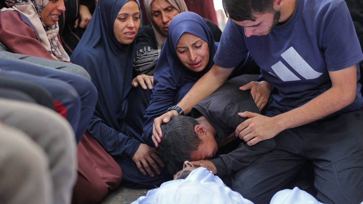 Palestinians mourn over the bodies of loved ones killed during overnight Israeli strikes, on the grounds of Al-Shifa hospital in the central Gaza Strip, June 28, 2025. (AFP Photo)