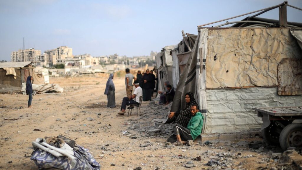 Palestinians sit in front of their makeshift home in the Bureij refugee camp in the central Gaza Strip on July 10, 2025. (Photo by Eyad BABA / AFP)