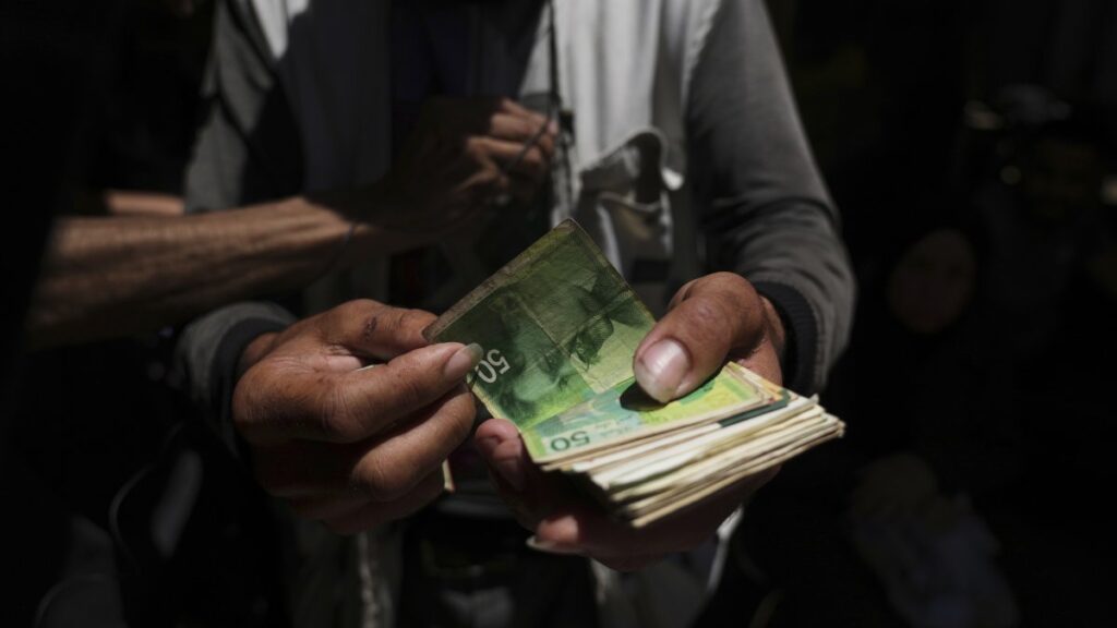 A Palestinian vegetable merchant shows worn-out Israeli currency, Gaza City, Palestine, July 9, 2025. (AP Photo)