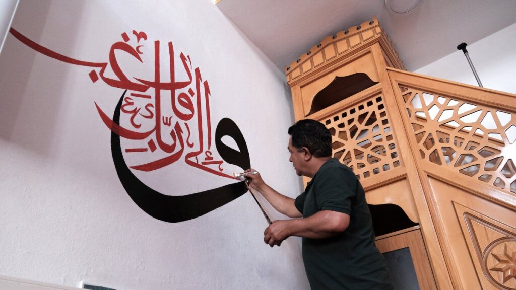 Mehmet Emin Deniz hand-paints Quranic calligraphy on a mosque wall using traditional techniques, Van, Türkiye, July 4, 2025. (AA Photo)