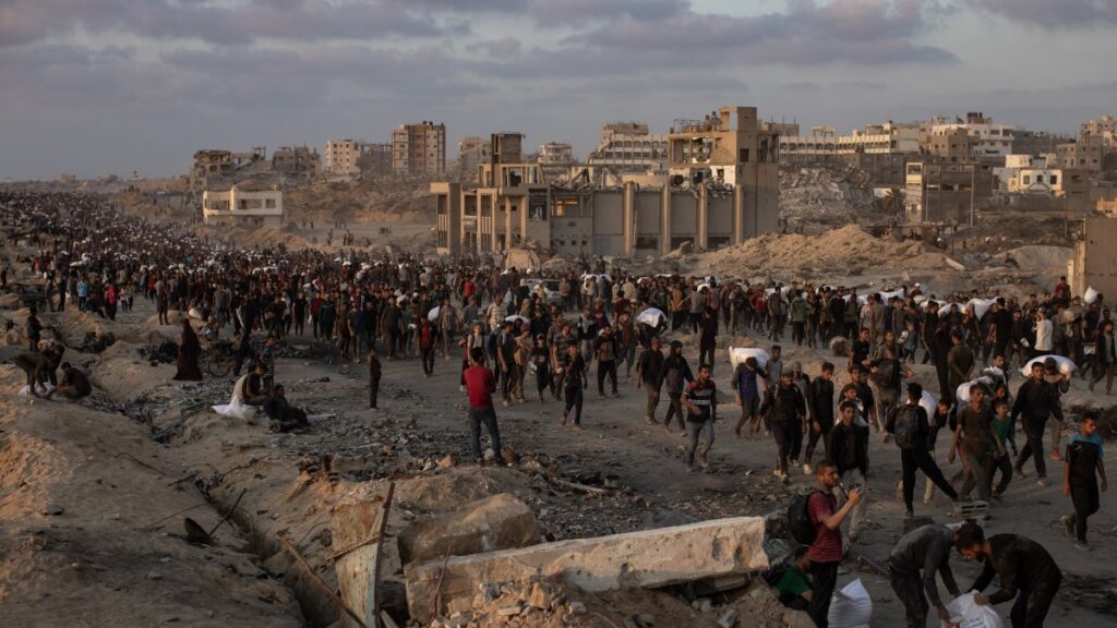 Displaced Palestinians carry bags of flour along Rashid Street in western Jabalia, June 17, 2025. (EPA Photo)