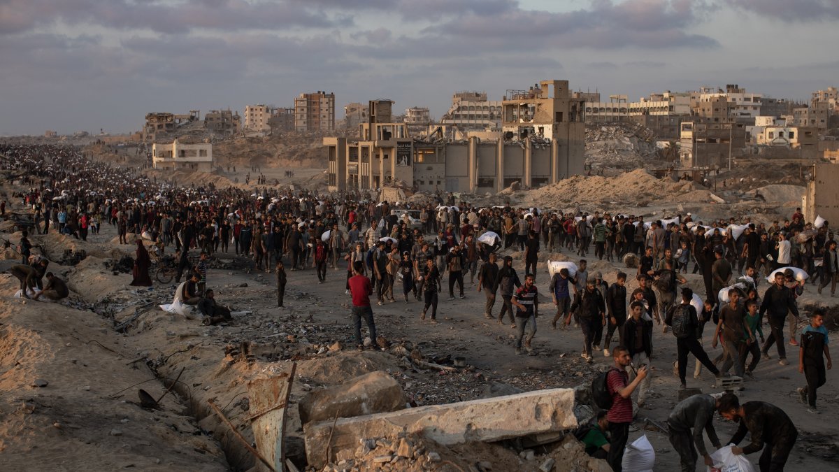 Displaced Palestinians carry bags of flour along Rashid Street in western Jabalia, June 17, 2025. (EPA Photo)