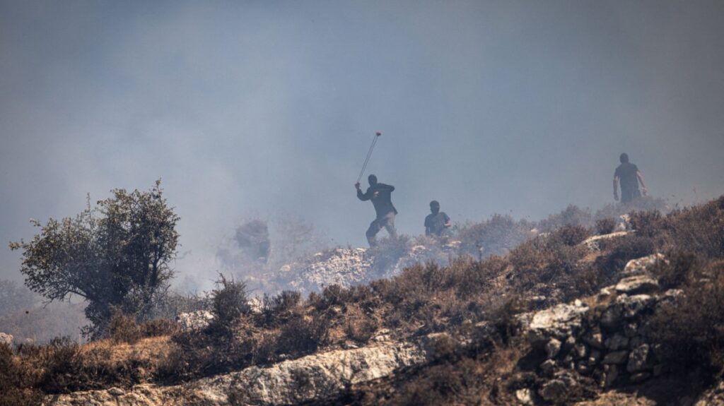 Masked Israeli settlers hurl rocks at Palestinians from hilltop in the village of Sinjil, in the occupied West Bank, Palestine, July 4, 2025. (AFP Photo)