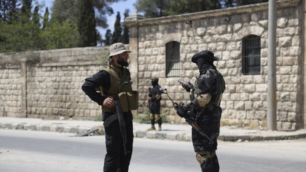 A member of the government security forces (L) speaks with a YPG terrorist during a prisoner exchange, Aleppo, Syria, June 2, 2025. (AP Photo)