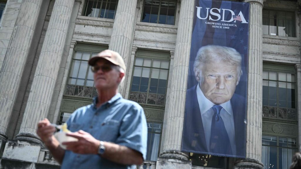 A man holds a bowl of ice cream following during a news conference with US Secretary of Health and Human Services Robert F. Kennedy Jr., as an image of U.S. President Donald Trump hangs outside the USDA headquarters building in Washington, DC, U.S., July 14, 2025. (AFP Photo)