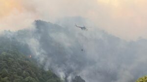 A firefighting helicopter conducts aerial water drops over a forest fire area to support containment efforts, Sakarya, Türkiye, July 23, 2025. (AA Photo)