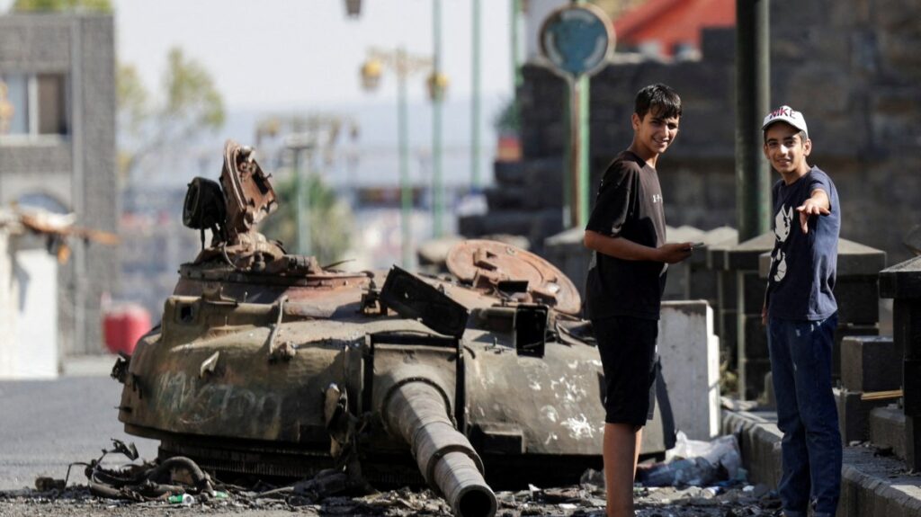 People stand next to a destroyed tank turret, following deadly clashes between Druze fighters, Sunni Bedouin tribes and government forces, in Syria's predominantly Druze city of Sweida, Syria July 25, 2025. (Reuters Photo)