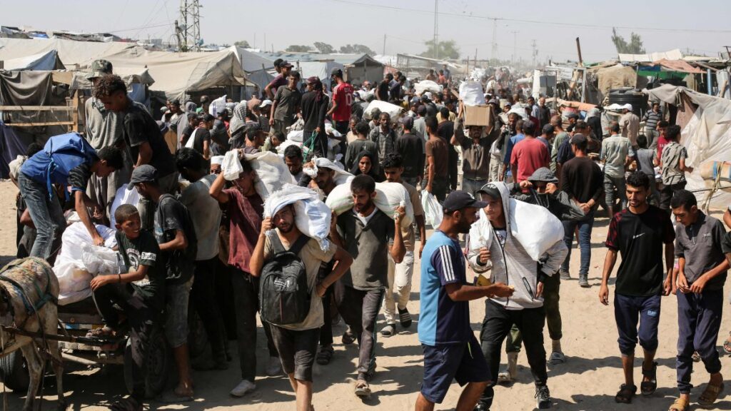 People carry food parcels and bags in the al-Mawasi camp in Rafah in the southern Gaza Strip, Palestine, July 27, 2025. (AFP Photo)