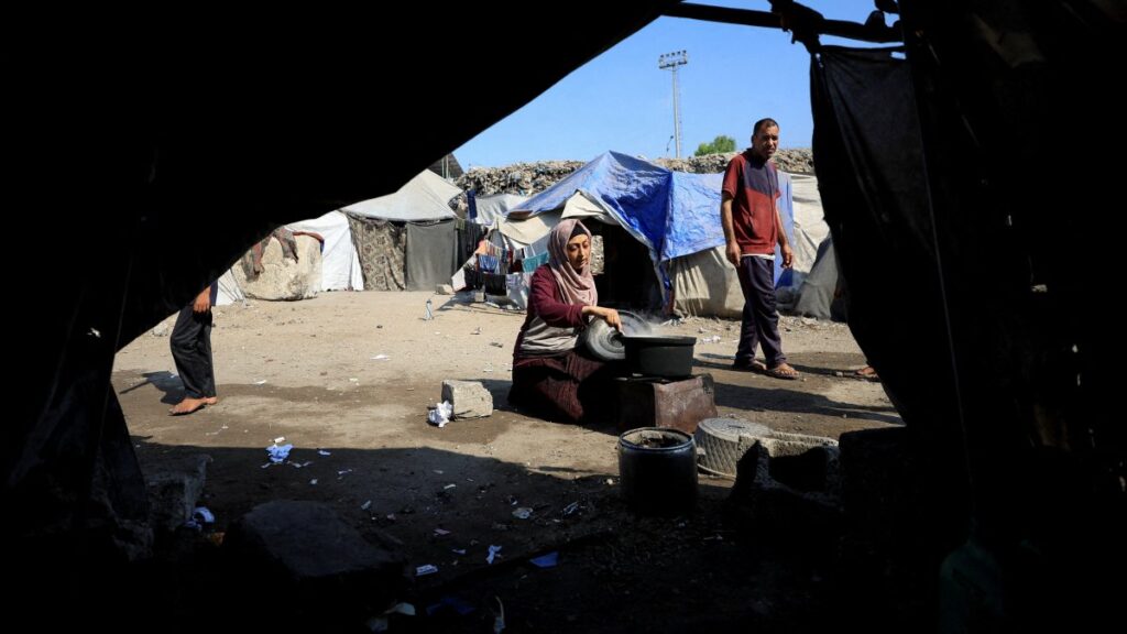 A woman cooks as displaced Palestinians who have not received humanitarian aid survive on leftover food, amid ongoing food shortages, in Gaza, Palestine, July 28, 2025. (Reuters Photo)