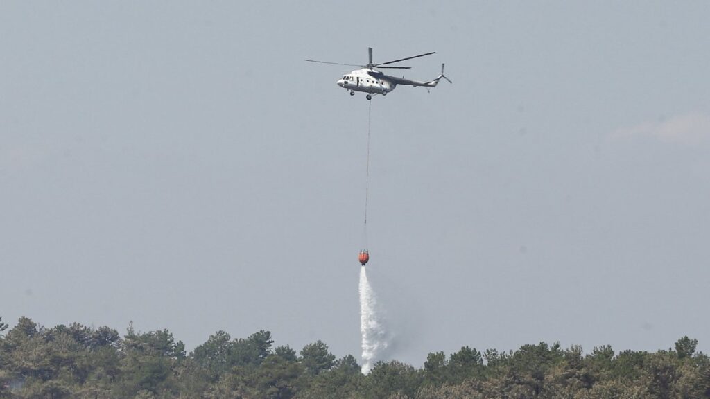 A helicopter assists firefighting efforts as the forest fire between Bursa’s Orhaneli and Harmancık districts enters its fifth day of containment, Bursa, Türkiye, July 30, 2025. (AA Photo)