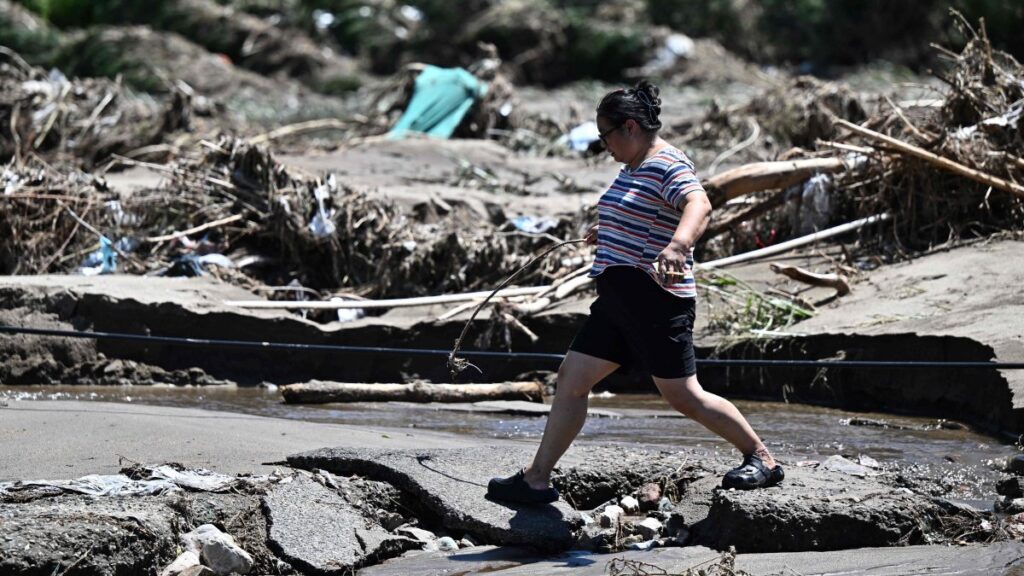 A woman walks past a flood-damaged area from heavy rains over the last few days in Huairou district, on the outskirts of Beijing, China, July 30, 2025. (AFP Photo)