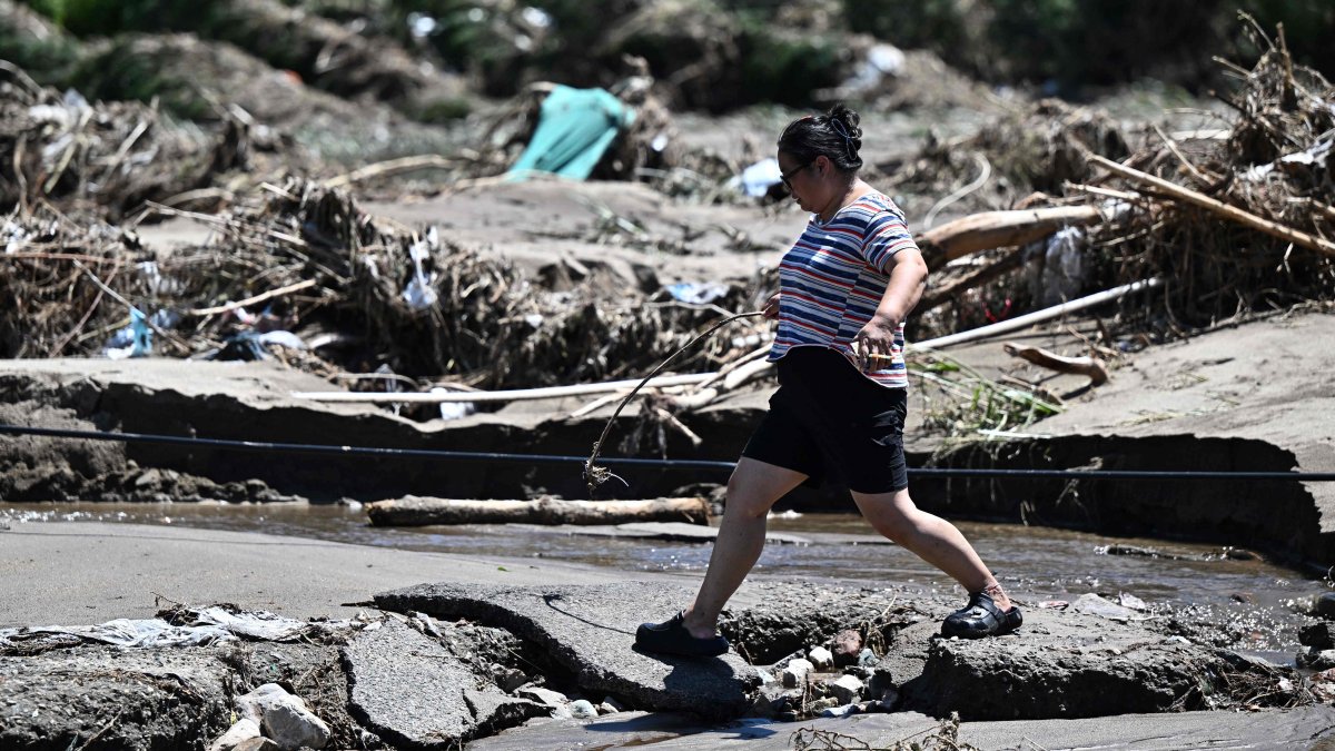 A woman walks past a flood-damaged area from heavy rains over the last few days in Huairou district, on the outskirts of Beijing, China, July 30, 2025. (AFP Photo)