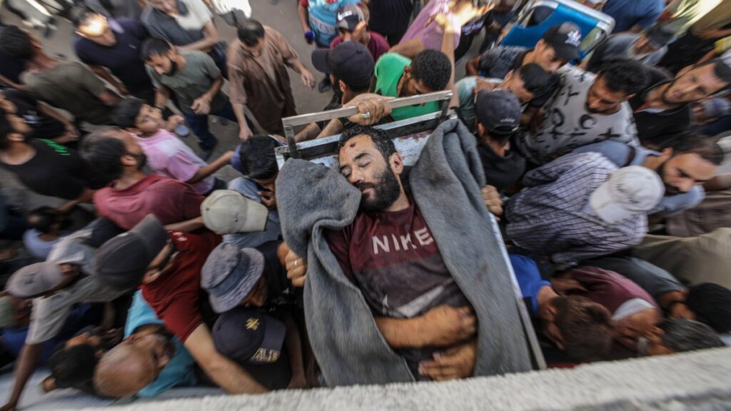 Palestinians carry the body of a young man outside al-Shifa Hospital after he was shot dead at a food distribution point near Zikim in Gaza City, central Gaza, July 31, 2025. (EPA Photo)