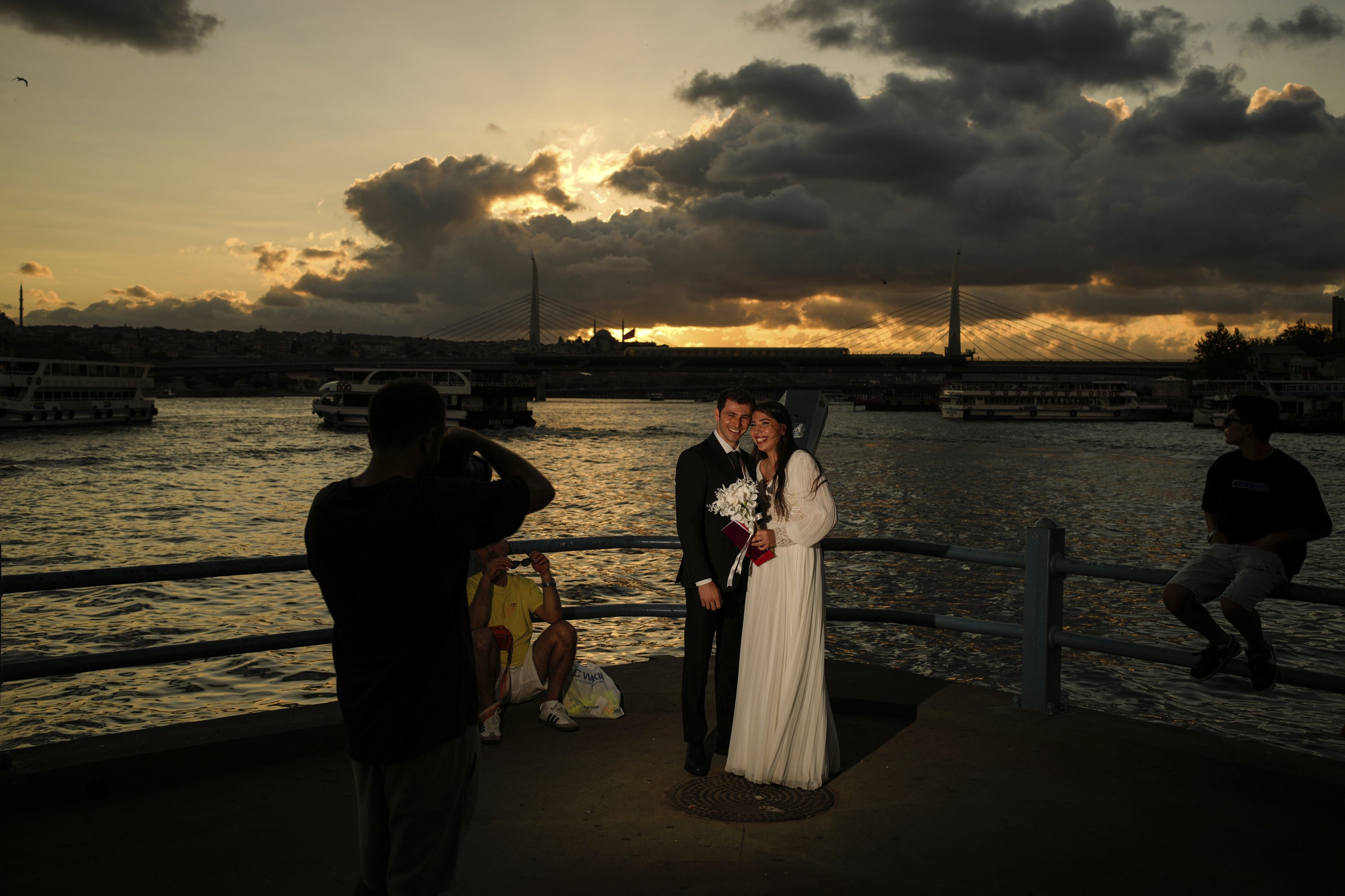 395833 Damla Avci (R) and her husband, Mustafa Ertan, pose during a photo session at Galata Bridge, Istanbul, Türkiye, July 31, 2025. (AP Photo)