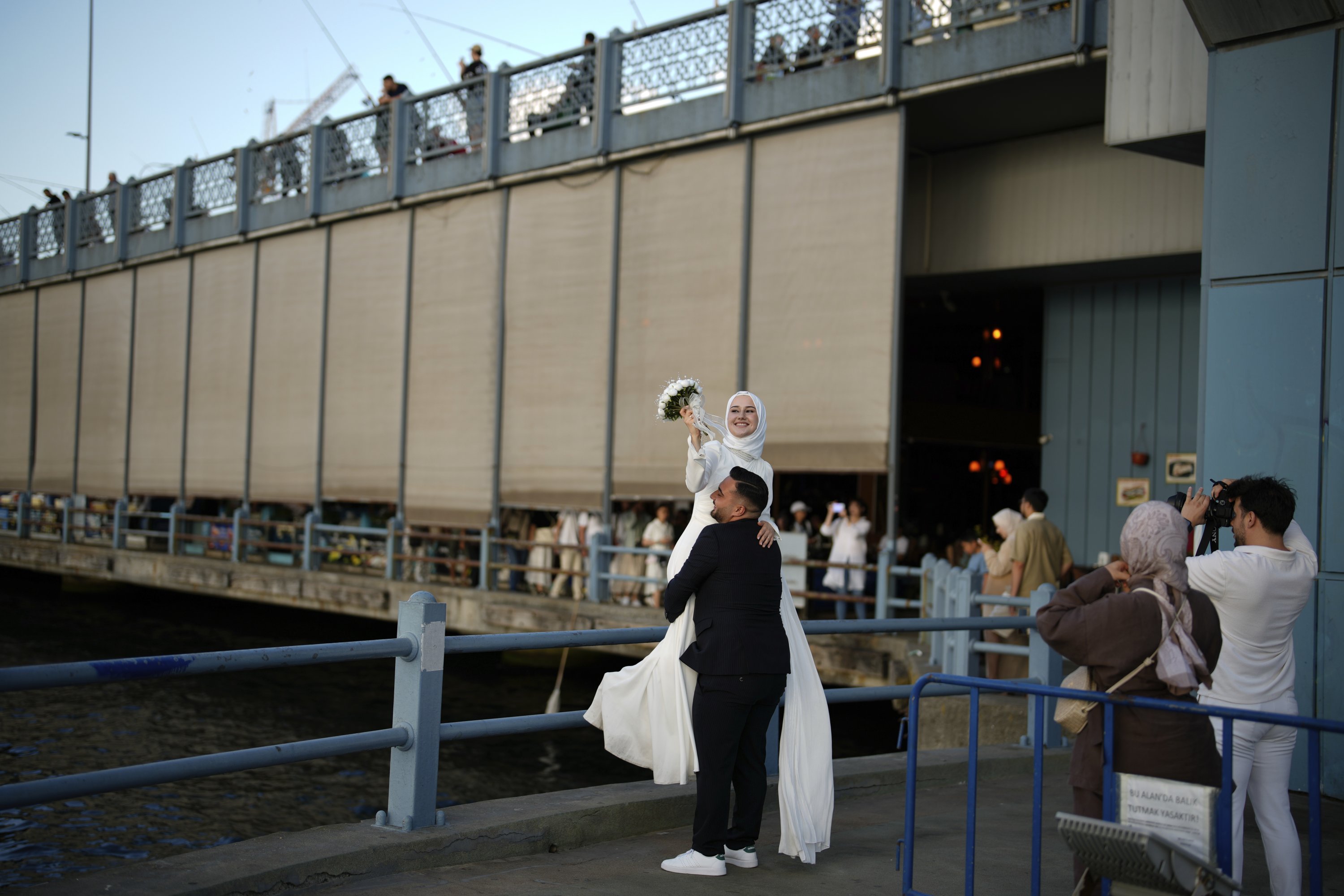 395837 Sude Keles and her husband Suat Keles pose during a photo session at Galata Bridge, Istanbul, Türkiye, July 28, 2025. (AP Photo)